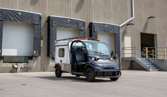 a black electric vehicle parked outside a garage