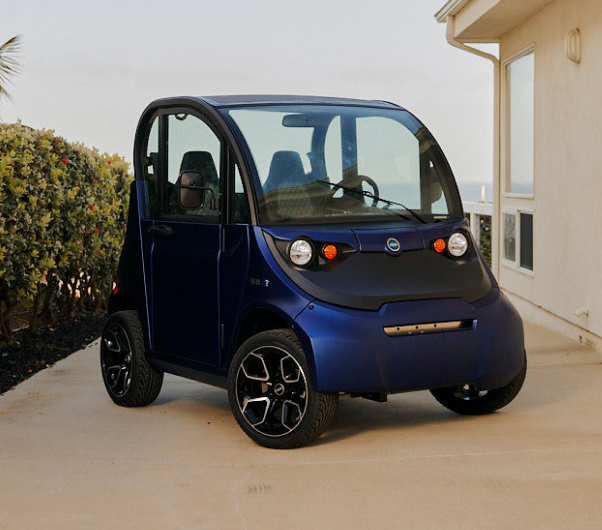 A blue electric vehicle parked in the driveway