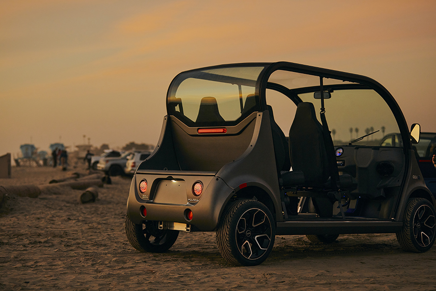 An electric vehicle parked on the beach at sundown