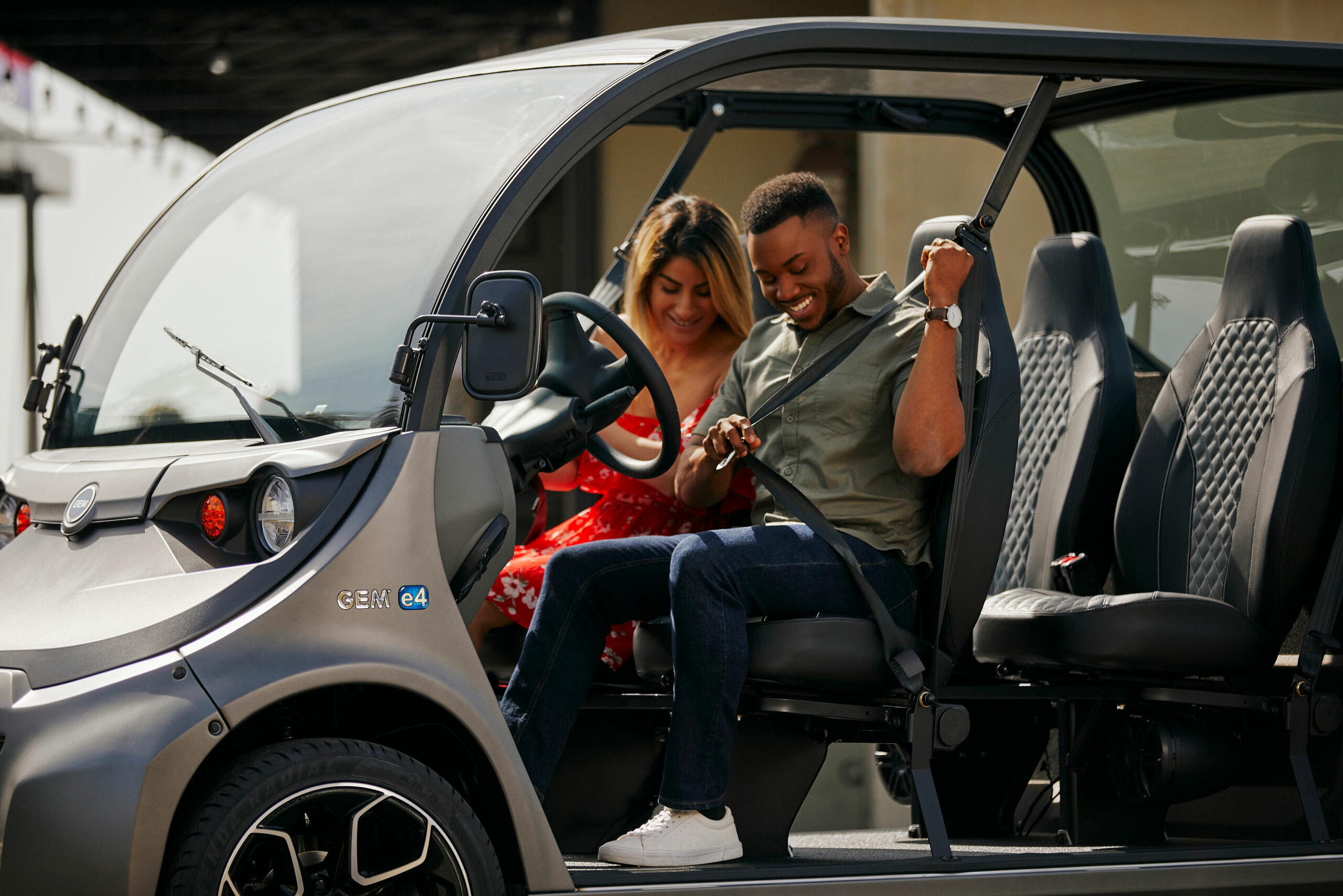 A man and a woman fastening their seatbelts in an electric vehicle