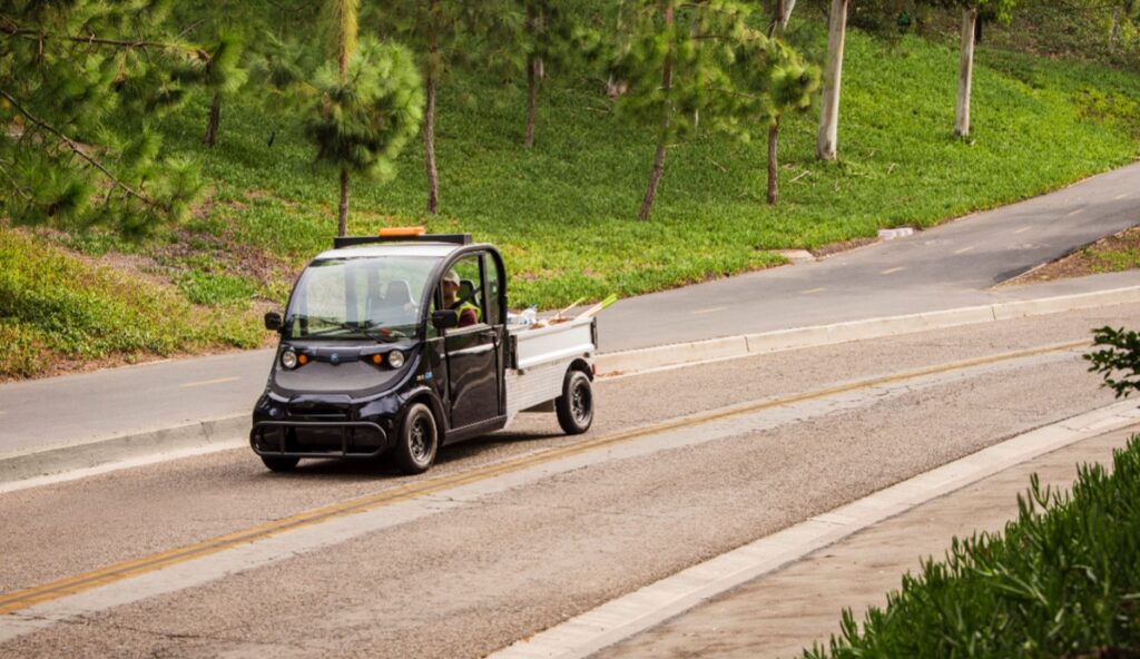An electric vehicle with a man in a safety vest driving